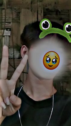 a person with a peace sign and a frog on their face in front of them