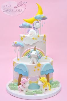 a three tiered cake with unicorns and stars on the top is decorated in pastel colors