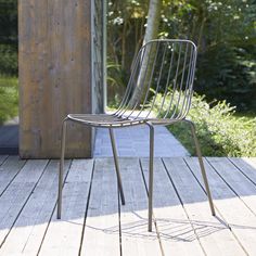 a metal chair sitting on top of a wooden deck