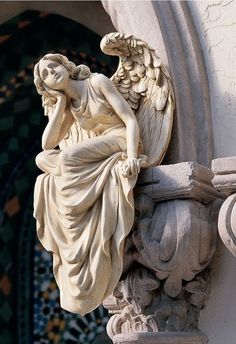 an angel statue on the side of a building