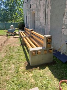 a wooden bench sitting in the grass next to a building