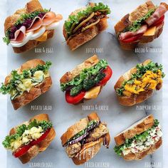 a bunch of sandwiches that are on top of a white board with different toppings