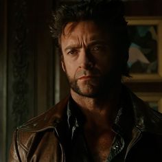 a man in a leather jacket looking at the camera