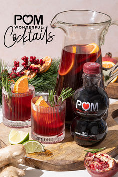 two glasses filled with red liquid and garnished with rosemary, orange slices and cranberries