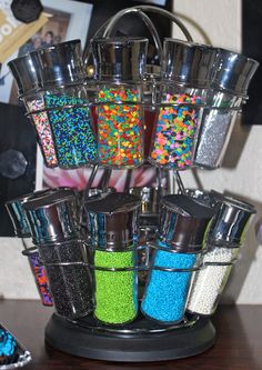 a metal container filled with lots of sprinkles on top of a wooden table