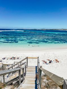 stairs lead down to the beach with clear blue water