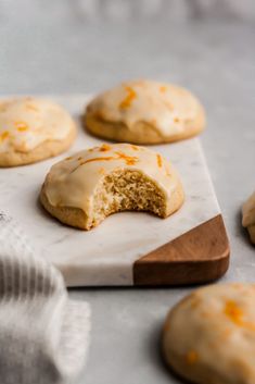 glazed cookies with orange icing on a cutting board