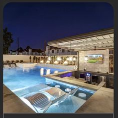 an outdoor swimming pool at night with lounge chairs around it and lights on the ceiling