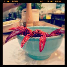 a bowl filled with red lobsters sitting on top of a table