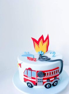 a white cake with a red fire truck on it's side and the words winz written on top