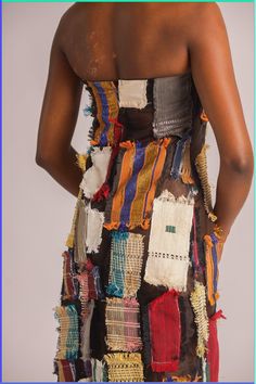 the back of a woman's dress covered in multicolored pieces of fabric