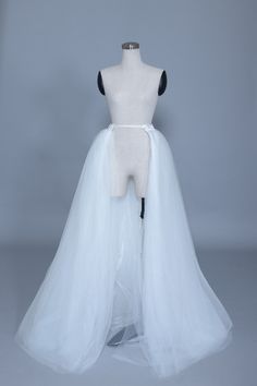 a mannequin wearing a white tulle skirt with black straps on the back