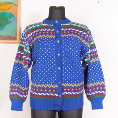 a mannequin wearing a blue cardigan with multicolored patterns on it