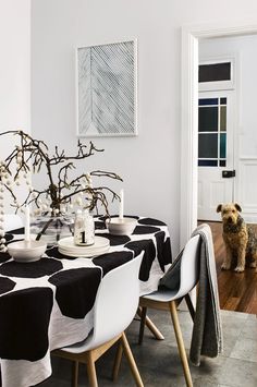 a black and white table cloth with polka dots on it is next to a dog