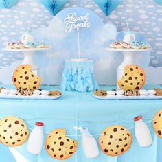 a dessert table with cookies and milk bottles