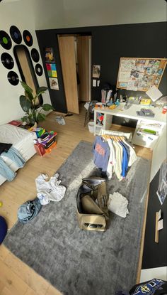 a messy bedroom with clothes on the floor