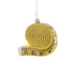 a yellow measuring ornament hanging from a chain on a white background with a tape measure in the shape of a snail