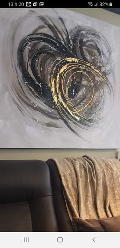 an abstract painting hanging on the wall in a living room