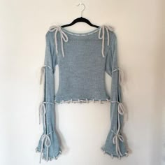 a cropped sweater hanging on a wall