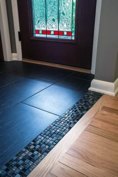 a wooden door with a glass window in the middle and tile on the floor next to it