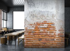 a brick wall in an empty room with tables and stools around the table area