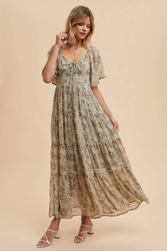 Get ready to turn heads at any wedding with our Isn't It Romantic Floral Dress! With its feminine and sweet design, this dress is the perfect choice for any fall wedding. Don't miss out on the opportunity to be the best-dressed guest! Color: Sage Floral maxi dress Sweetheart neckline Decorative tie front Flutter sleeves Fully lined 100% polyester Flowy Empire Waist Bridesmaid Dress, Flowy Feminine Floral Dress For Wedding, Feminine Flowy Floral Dress For Wedding, Chiffon Floral Dress For Wedding, Feminine Tiered Bridesmaid Dresses, Bohemian Floral Print Dress With Sweetheart Neckline, Bohemian Floral Dress With Sweetheart Neckline, Flowy Floral Maxi Dress For Wedding, Bohemian Dress With Floral Print And Sweetheart Neckline