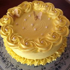 a cake with yellow frosting and butterflies on it