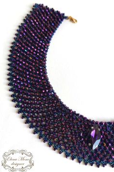 a purple and black beaded necklace on a white background