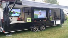 a black trailer with two televisions on it's sides