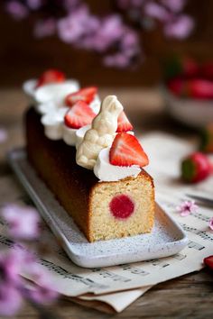 a piece of cake with strawberries and whipped cream on top sits on a sheet of music paper