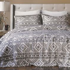 a bed with white and black bedspread in a bedroom