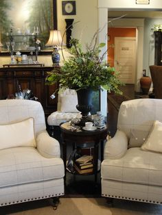 two white chairs sitting next to each other in a living room