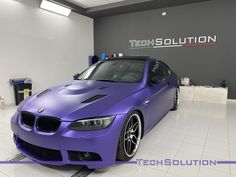 a purple car parked in a showroom with the word tech solution written on it