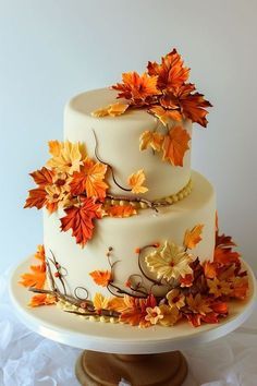 a three tiered cake decorated with fall leaves