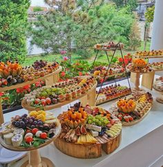 an assortment of food is displayed on a long table in front of a large window