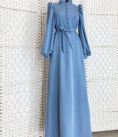 Lined with buttons and elegant cuff sleeves, this abaya dress is a must-have! Elegant Long Sleeve Maxi Dress With Modesty Panel, Elegant Eid Maxi Dress, Elegant Blue Long Sleeve Abaya, Elegant Long Sleeve Blue Abaya, Solid Long Sleeve Dresses For Eid, Elegant Long Maxi Dress With Modesty Panel, Modest Long Sleeve Maxi Dress With Buttons, Modest Blue Maxi Length Abaya, Elegant Blue Maxi Dress For Eid