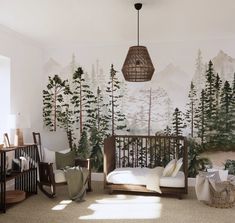 a baby's room decorated with pine trees, mountains and forest mural on the wall