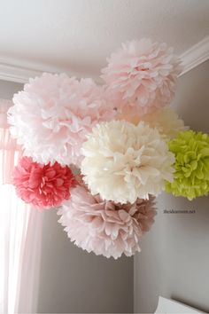 some pink and green flowers hanging from the ceiling in front of a window with an ebay sign below it