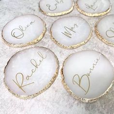 six personalized glass coasters with gold foil on them, sitting on a marble surface