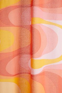 an orange, yellow and pink curtain hanging from a window