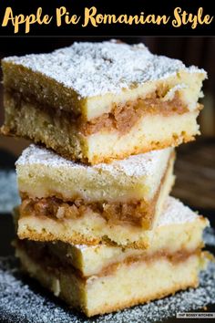 three pieces of cake sitting on top of a black plate covered in powdered sugar