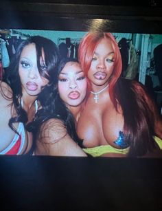 three beautiful women posing for the camera in front of a television screen with an image of them