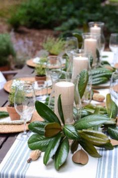 the table is set with candles and greenery for an outdoor dinner party or celebration