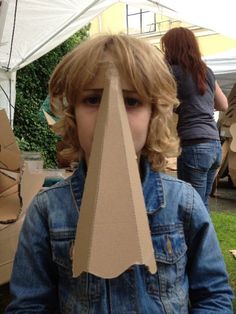 a young boy with a cardboard cut out of his face in front of an umbrella