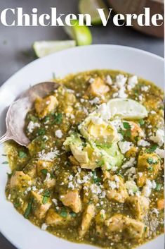 a white bowl filled with chicken and avocado soup on top of a table