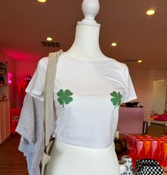 Celebrate St. Patrick's Day in bold style with our Shamrock Nipple Crop Top, designed exclusively for those looking to make a daring statement during the festivities. This eye-catching piece combines the playful spirit of St. Patty's Day with a cheeky design, ensuring you'll be the center of attention at any celebration. Crafted from soft, breathable fabric, this crop top is both comfortable and flattering, featuring a snug fit that accentuates your silhouette. The highlight of the design is the cleverly placed shamrock graphics, positioned to add a whimsical touch while embracing the theme of the holiday. Trendy White Crop Top For Festival, Trendy Halloween Festival Tops, Trendy Fitted Top For Festival, Fun Spring Festival T-shirt, Trendy White Festival T-shirt, Trendy White T-shirt For Festivals, Fun Spring Tops For Music Festival, Playful Spring Party Tops, Fitted Fun Festival Tops