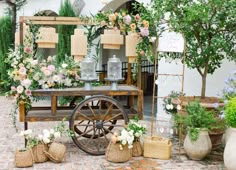 an old fashioned wagon with flowers and plants on display