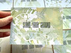 someone holding up a business card that says stand your ground