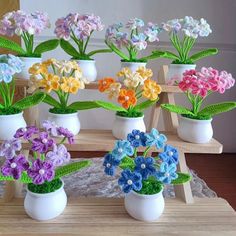 there are many small vases with flowers in them sitting on the wooden table and ready to be made into decorations