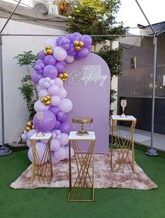 purple and gold balloon arch with happy birthday sign